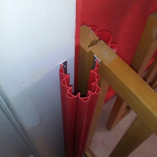 Kit anti pince doigts rouge installé sur portail en bois