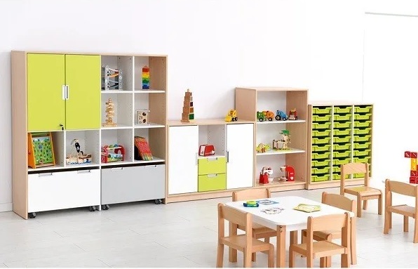 Classe de maternelle organisée avec espaces de travail, regroupement et coin lecture visibles